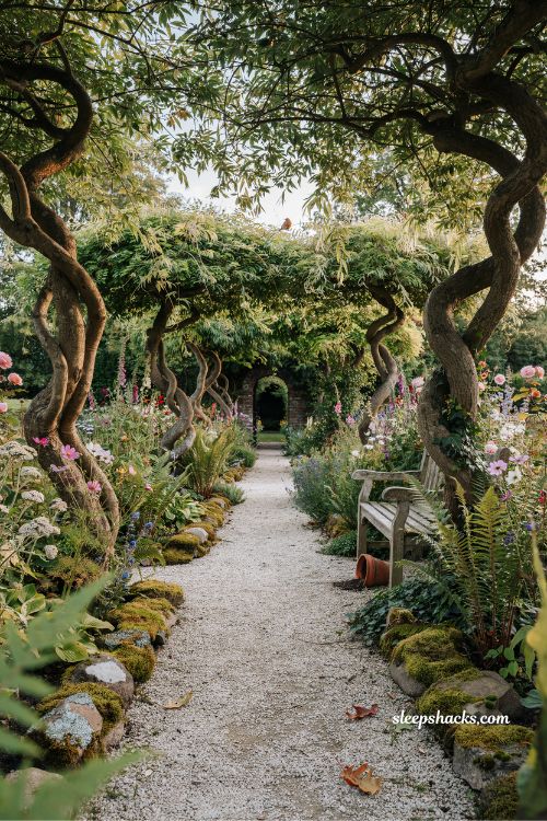 Garden fairytale ideas with twisted willow trees framing a secret garden path