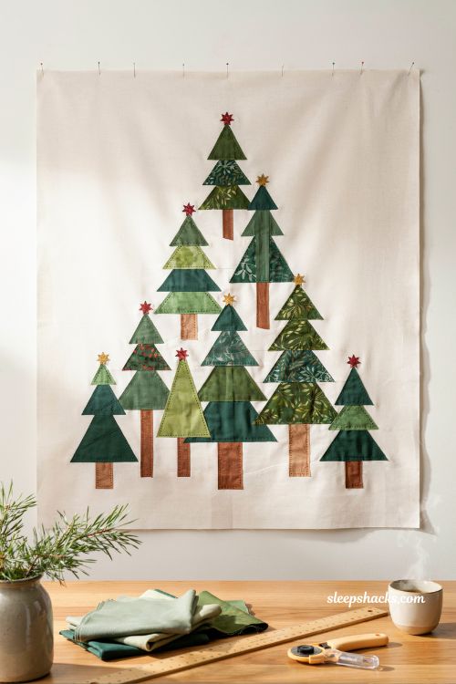 Improv patchwork christmas tree quilt handmade folk art forest wall hanging in cozy sewing studio with green fabric trees and minimalist holiday decor