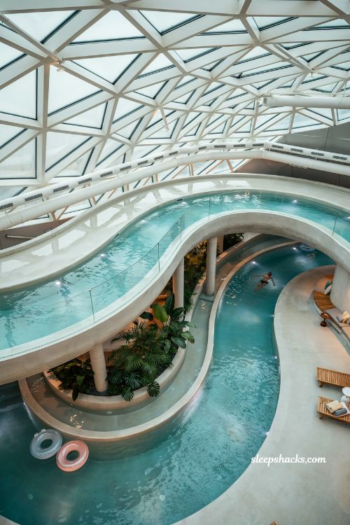 Indoor lazy river pool with glass roof year round floating natatorium design ideas