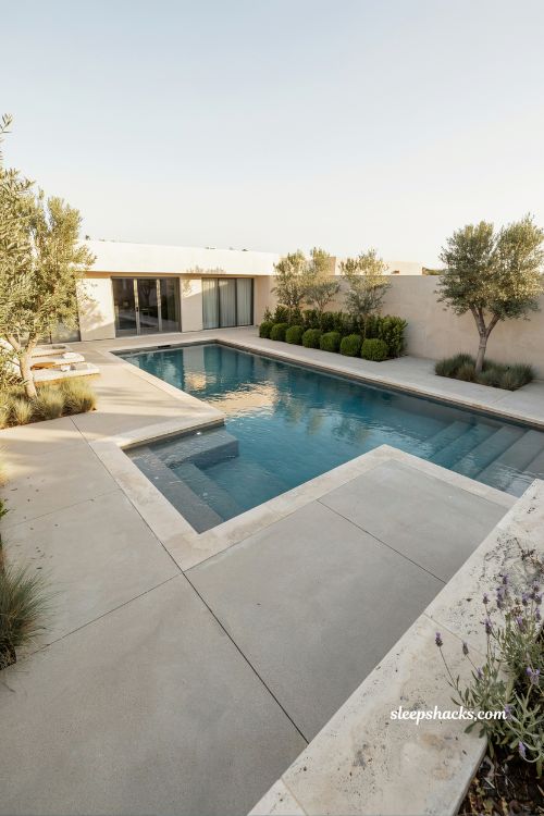 L-shaped backyard pool with integrated corner hot tub creating a modern luxury outdoor spa and swimming design that follows the natural architecture of the home
