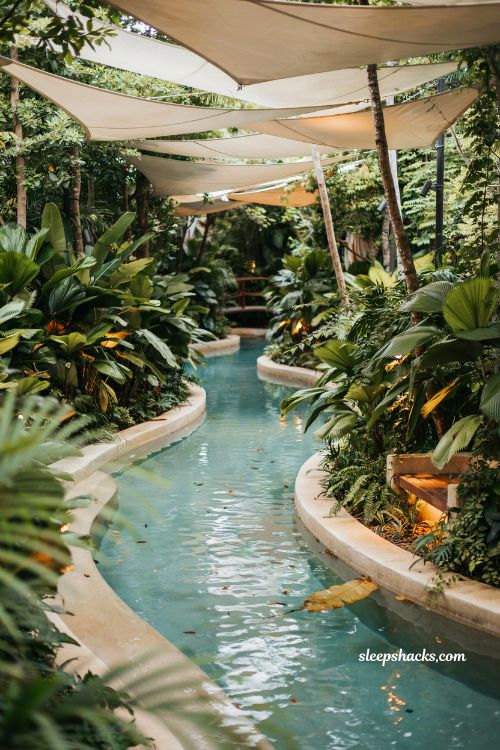 Lazy river with tropical overhanging plants and shade sails backyard resort shaded pool design ideas
