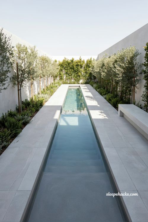 Long narrow backyard lap pool design with minimalist decking and clean modern architectural layout for compact fitness-focused outdoor living