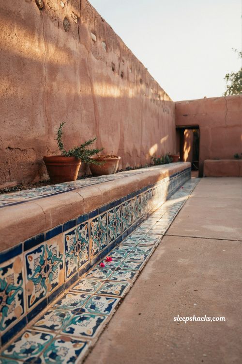 Mexican hacienda patio ideas with hand painted tile details terracotta courtyard walls azulejo border pathway rustic colorful ceramic design