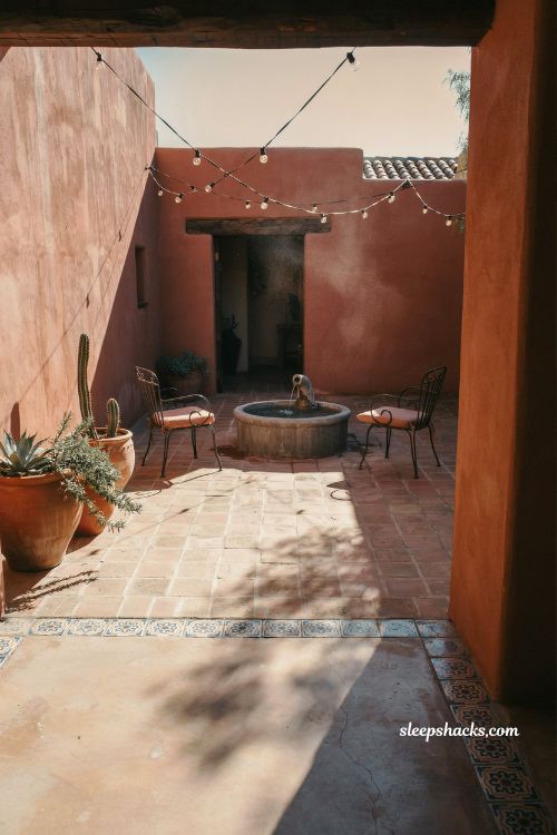 Mexican hacienda patio ideas with terracotta walls courtyard fountain string lights rustic outdoor space warm adobe backyard design sunset ambiance