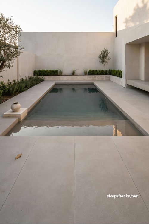 Minimalist geometric pool design with modern concrete tiles and sleek architectural backyard finish