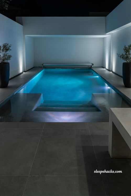 Modern inground pool with LED lighting at night sleek luxury backyard design with color changing lights and minimalist contemporary style