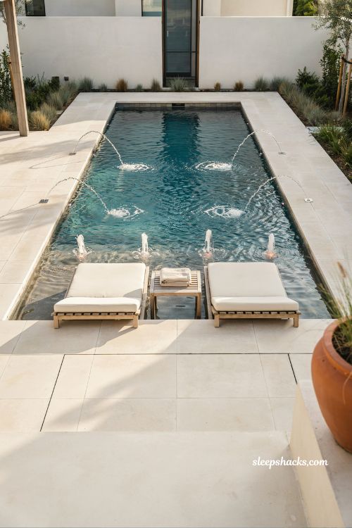 Modern pool design with deck jets and bubbler water features for elegant backyard movement and light effects