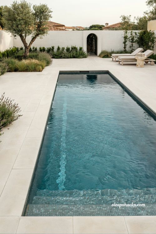Modern pool design with patterned mosaic waterline tiles and sleek luxury backyard finish