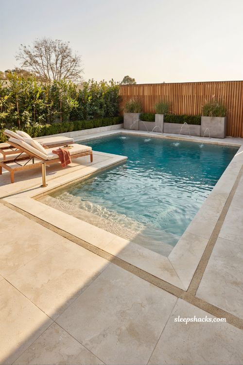 Modern pool sun ledge design with in-water loungers and backyard family relaxation space
