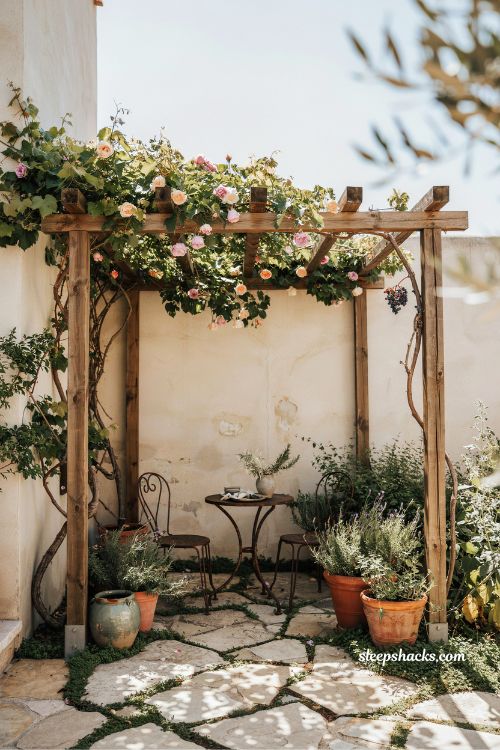 Small mediterranean garden ideas with a small pergola draped in climbing vines over a cozy courtyard seating area 