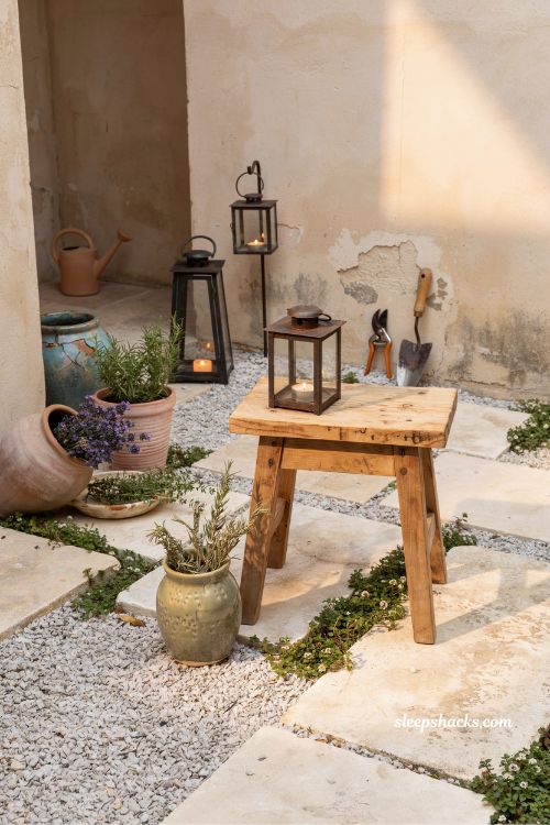 Small mediterranean garden ideas with weathered iron lanterns and rustic collected decor for a lived-in courtyard aesthetic 