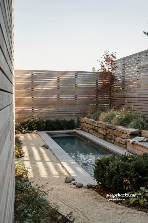 Small sloped backyard ideas with cedar horizontal slat fencing and private zen pool retreat