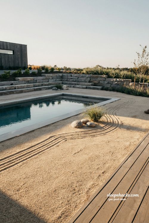 Small sloped backyard ideas with raked gravel beds and minimalist zen pool design