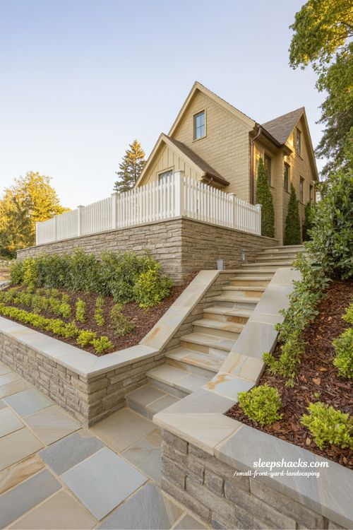 Small sloped front yard landscaping with stone retaining wall and symmetrical stair entry design