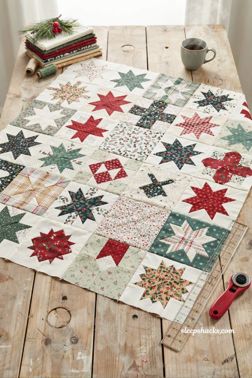 No point stars patchwork christmas quilt with scrappy red green and cream star blocks on farmhouse quilting table in cozy holiday sewing studio with handmade folk art charm