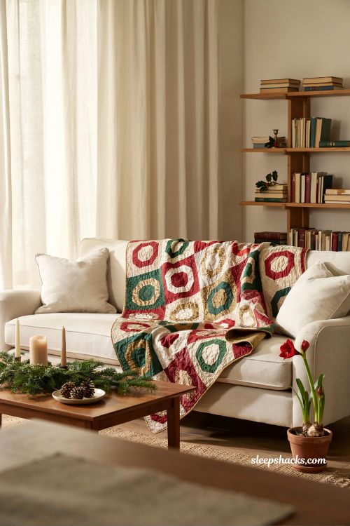 Winter wreaths throw quilt with red and green patchwork wreath pattern draped on cozy holiday living room sofa with elegant Christmas decor styling