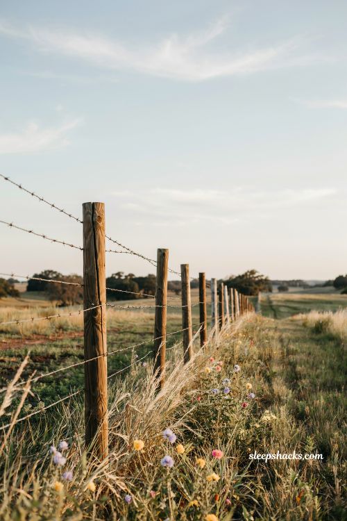 barbed wire wooden post fence ideas rustic ranch boundary with open field and farmhouse countryside aesthetic