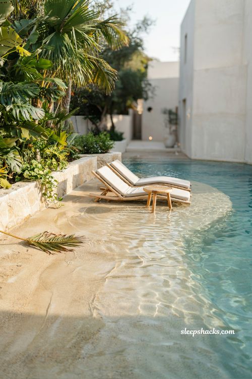 beach entry pool with lounge chairs placed in shallow water luxury resort design