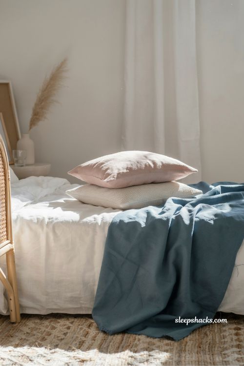 blue throw blanket layered on bed coastal bedroom idea with pink and blue airy seaside styling