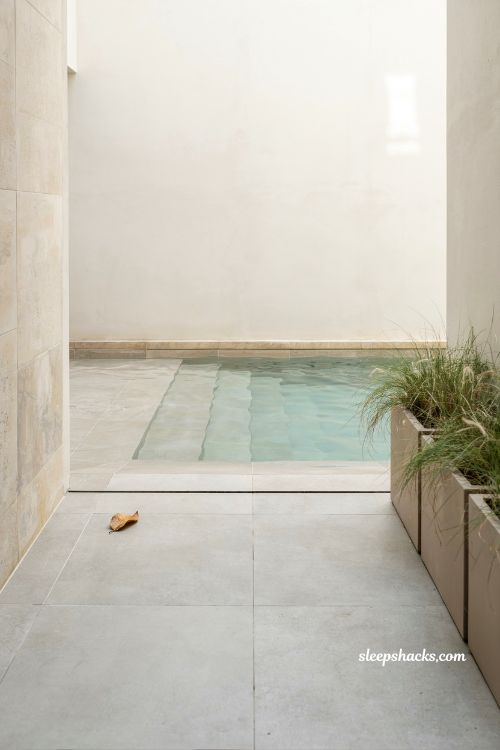 clean porcelain tile beach entry pool slope with boutique hotel minimalist design