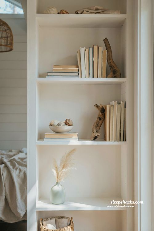 coastal teen bedroom bookshelf styling with driftwood bookends and shell decor curated coastal aesthetic