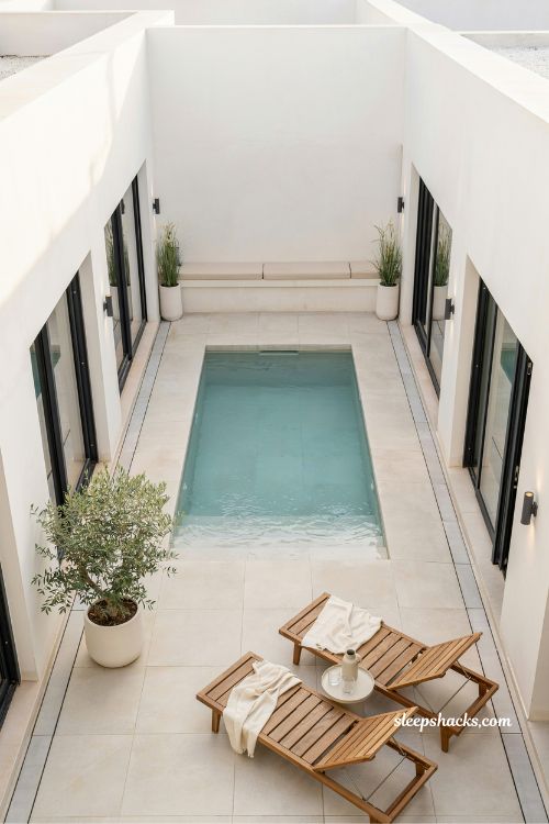 compact courtyard pool design for small villa spaces with light tiles and modern minimalist luxury aesthetic