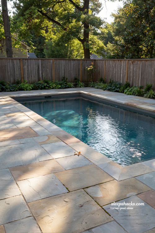 flagstone decking wrapped around corner lap pool modern backyard stone pool design with natural landscape feel