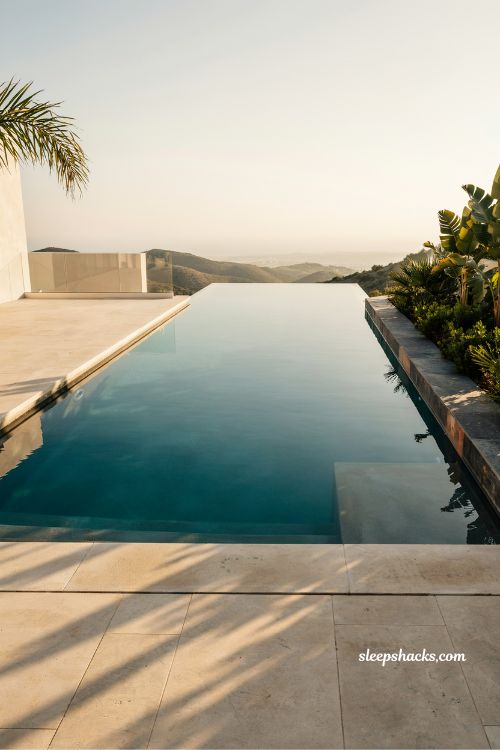 infinity edge pool design that melts into horizon with luxury villa landscape view at golden hour