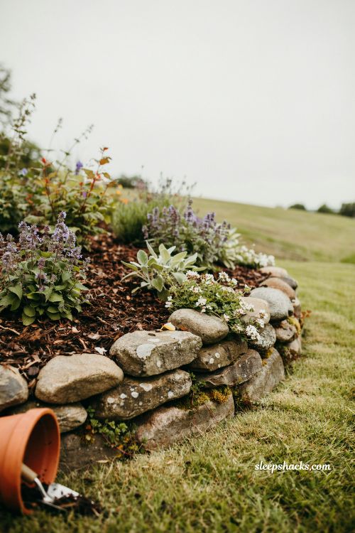 layered fieldstone edging ideas for small sloped backyard garden beds to prevent mulch erosion
