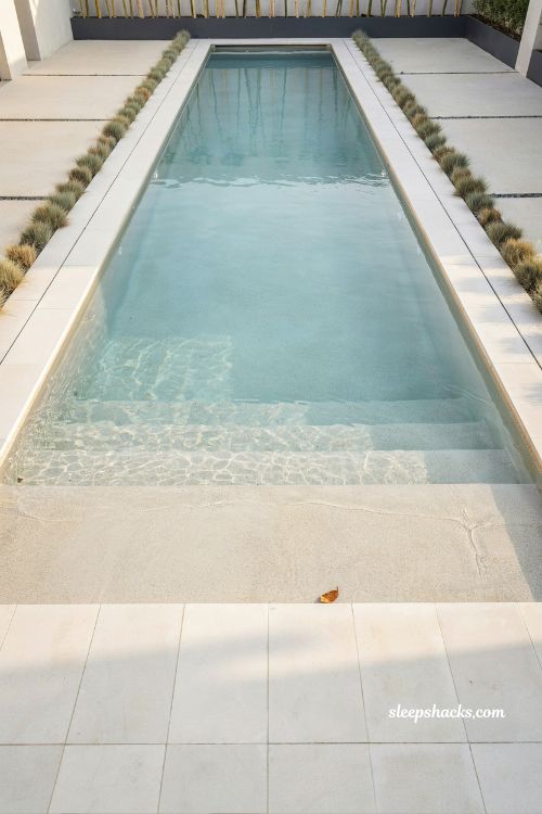 modern geometric pool with wide symmetrical beach entry and concrete deck design
