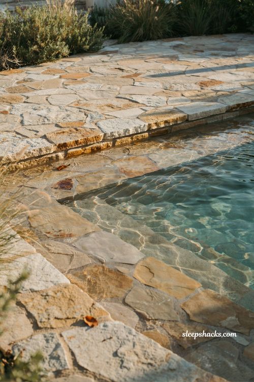 natural flagstone pool deck flowing into beach entry shallow water seamless design