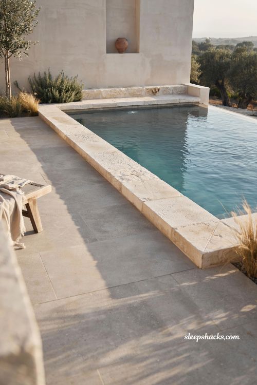 natural stone pool decking design with calm water retreat and minimalist luxury outdoor spa aesthetic