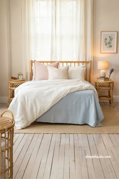 pastel blue bedsheets under white duvet coastal bedroom idea with soft pink and blue boutique seaside styling