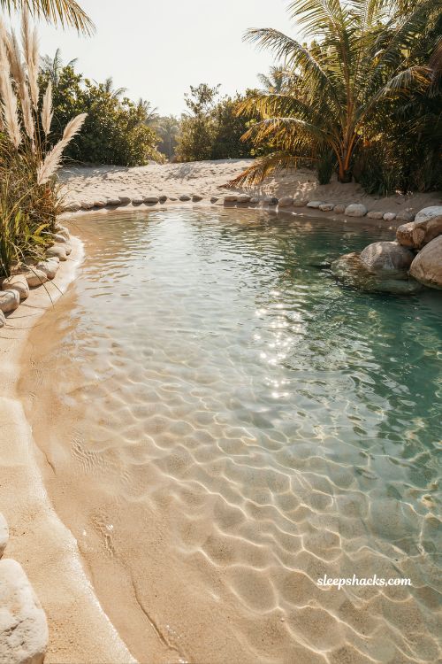 real sand beach entry pool with natural lagoon style shallow water floor design