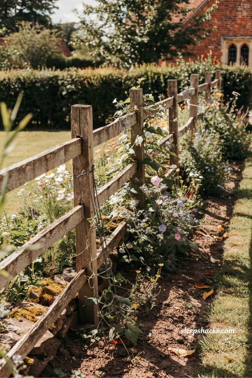 rustic garden fence ideas with weathered wood and natural wildflower landscaping for cozy backyard inspiration