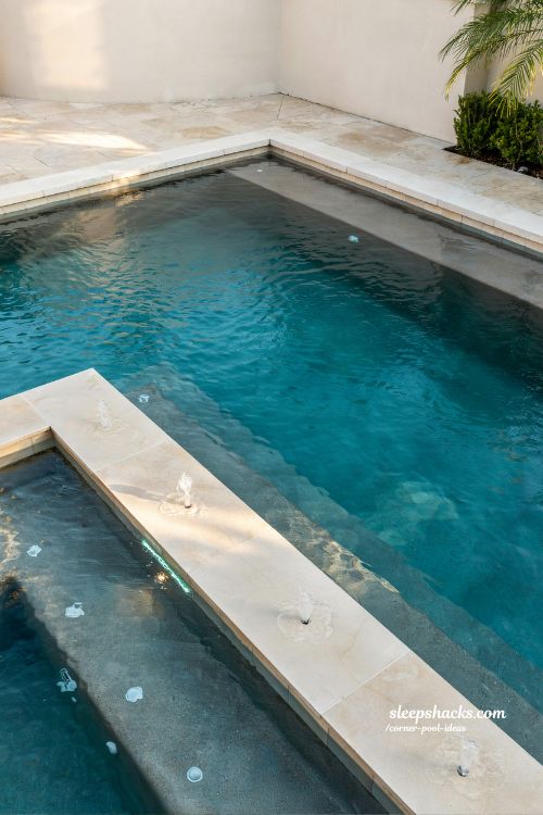 tanning ledge built into corner of pool with LED bubblers modern luxury backyard shallow lounge pool design