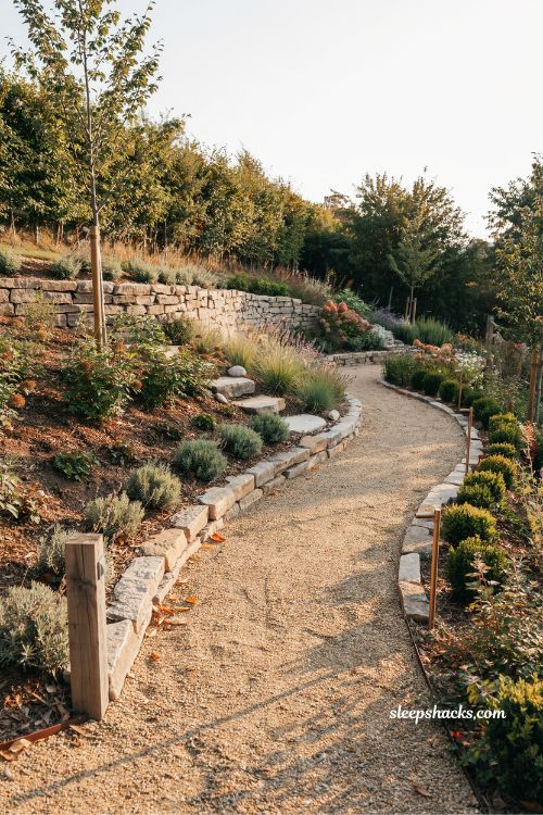 winding gravel path ideas for small sloped backyard connecting terraced garden levels