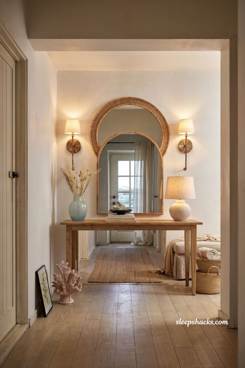 Beach house entryway ideas with aged brass sconces and layered coastal lighting