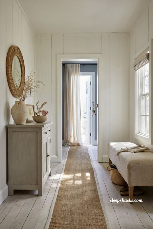 Beach house entryway ideas with rattan mirror and layered coastal wall decor