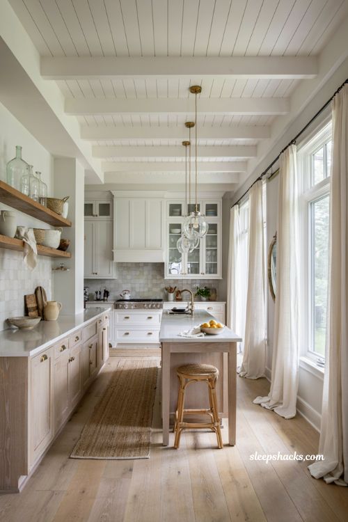 Beachy kitchen decor ideas with clear glass cabinets mirrors and airy coastal style