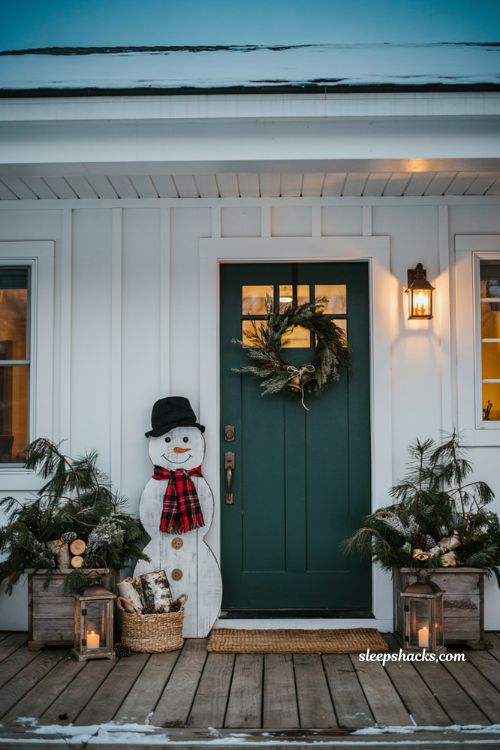 Christmas front door ideas with rustic wooden snowman decoration and cozy farmhouse porch