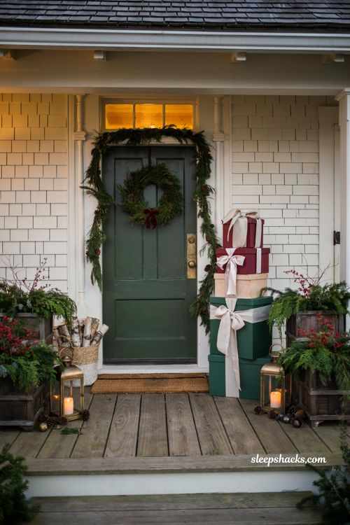 Christmas front door ideas with stacked wooden present decorations and simple evergreen wreath