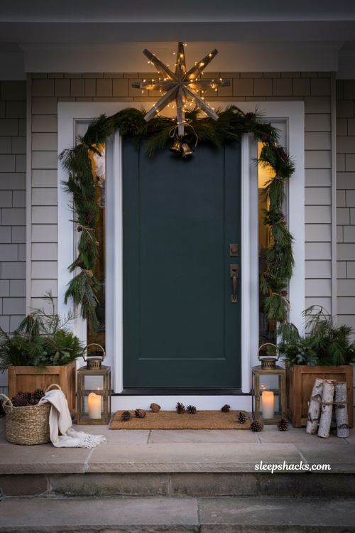 Christmas front door ideas with wooden North Star decoration and glowing string lights
