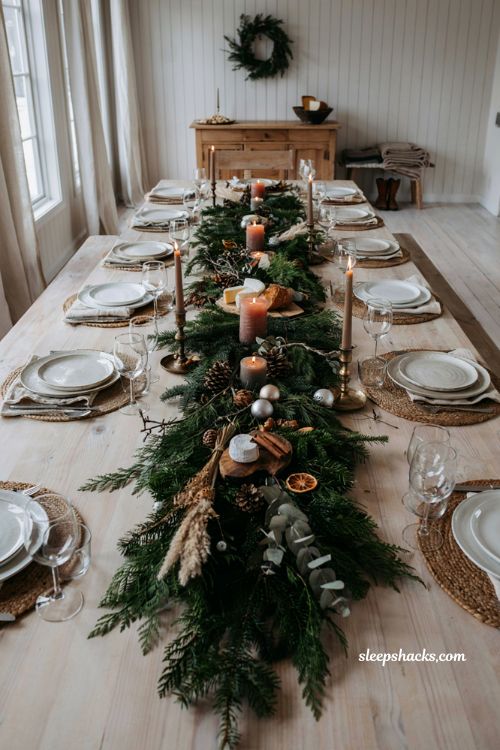 Christmas table settings ideas with evergreen garland runner and natural holiday centerpiece