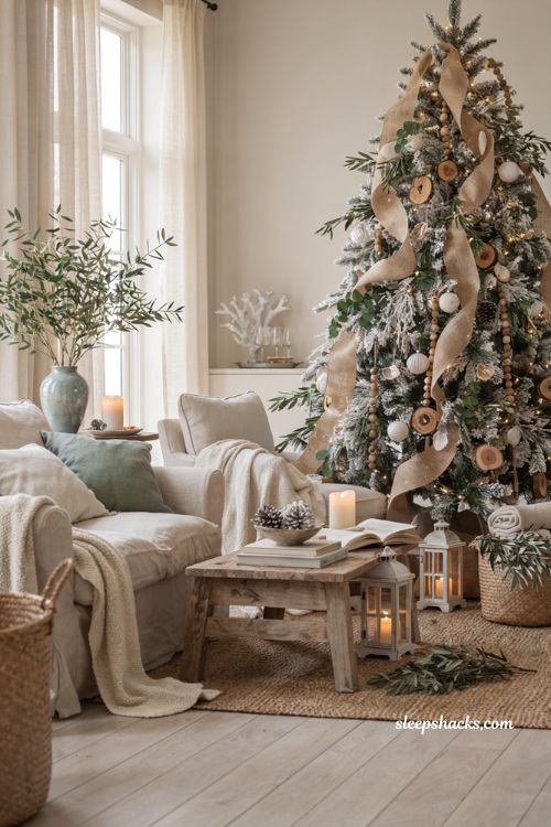 Coastal christmas living room with a flocked tree wrapped in burlap ribbon and natural holiday decor