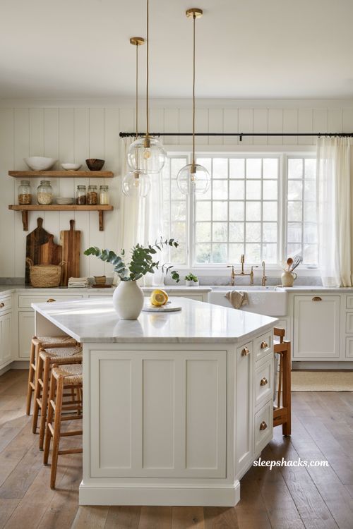Coastal farmhouse kitchen ideas with clear glass pendant lights over the island