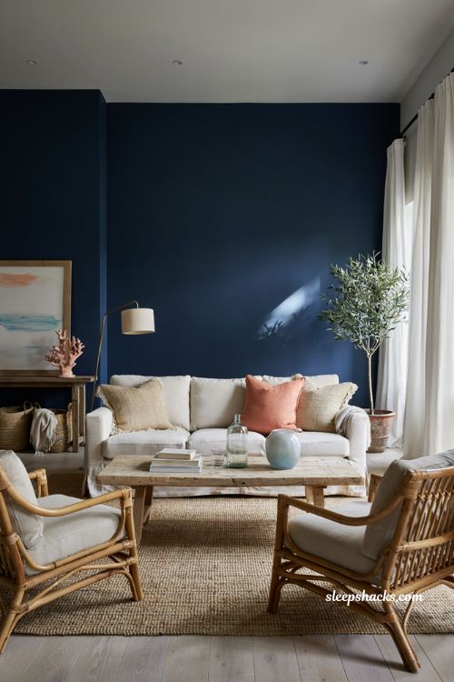 Coastal-inspired living room with navy walls and oversized coral decor accents