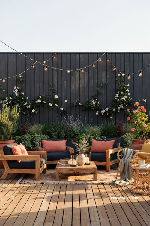 Colorful backyard ideas with charcoal painted privacy fence and vibrant garden decor