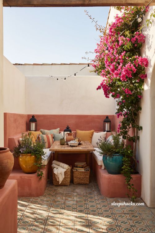 Colorful backyard ideas with coral built in banquette and patterned outdoor pillows