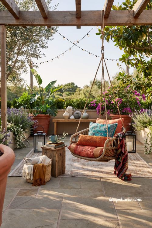 Colorful backyard ideas with woven hanging chair and bold patterned outdoor cushions